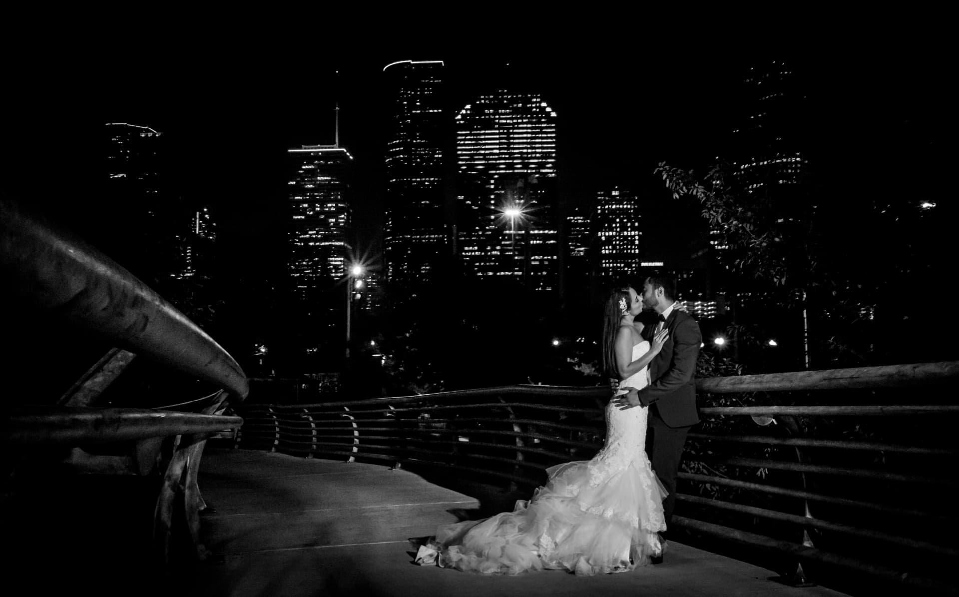 Novios besándose de noche frente al skyline de Chicago, sesión trash the dress en blanco y negro