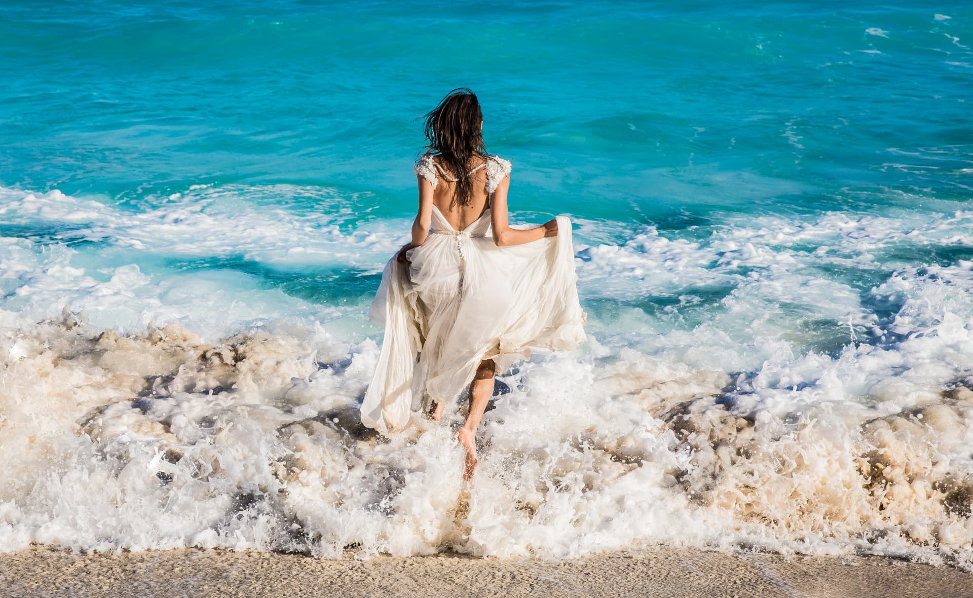 Novia entrando al mar Caribe con su vestido, sesión trash the dress