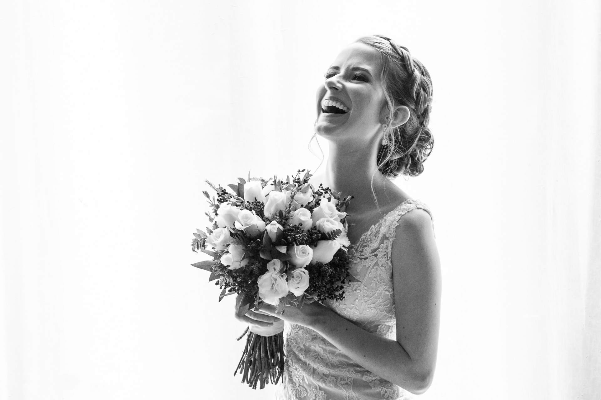 Novia riendo con su ramo, retrato en blanco y negro de alta luminosidad