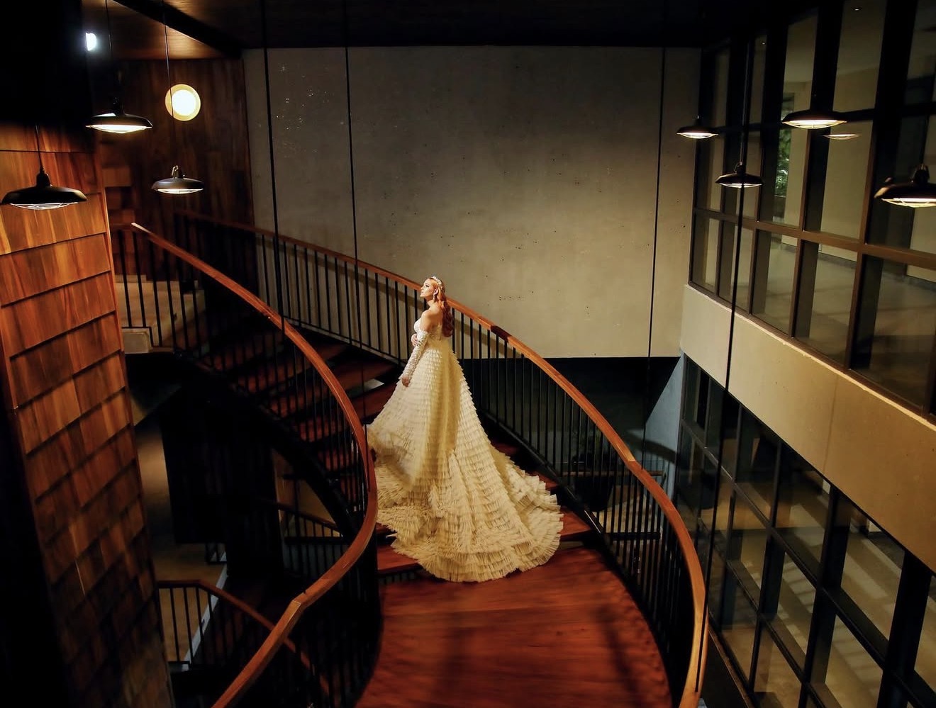 Novia con vestido de volantes descendiendo una escalera de caracol